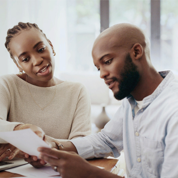 A young couple looking at statements and developing a savings strategy