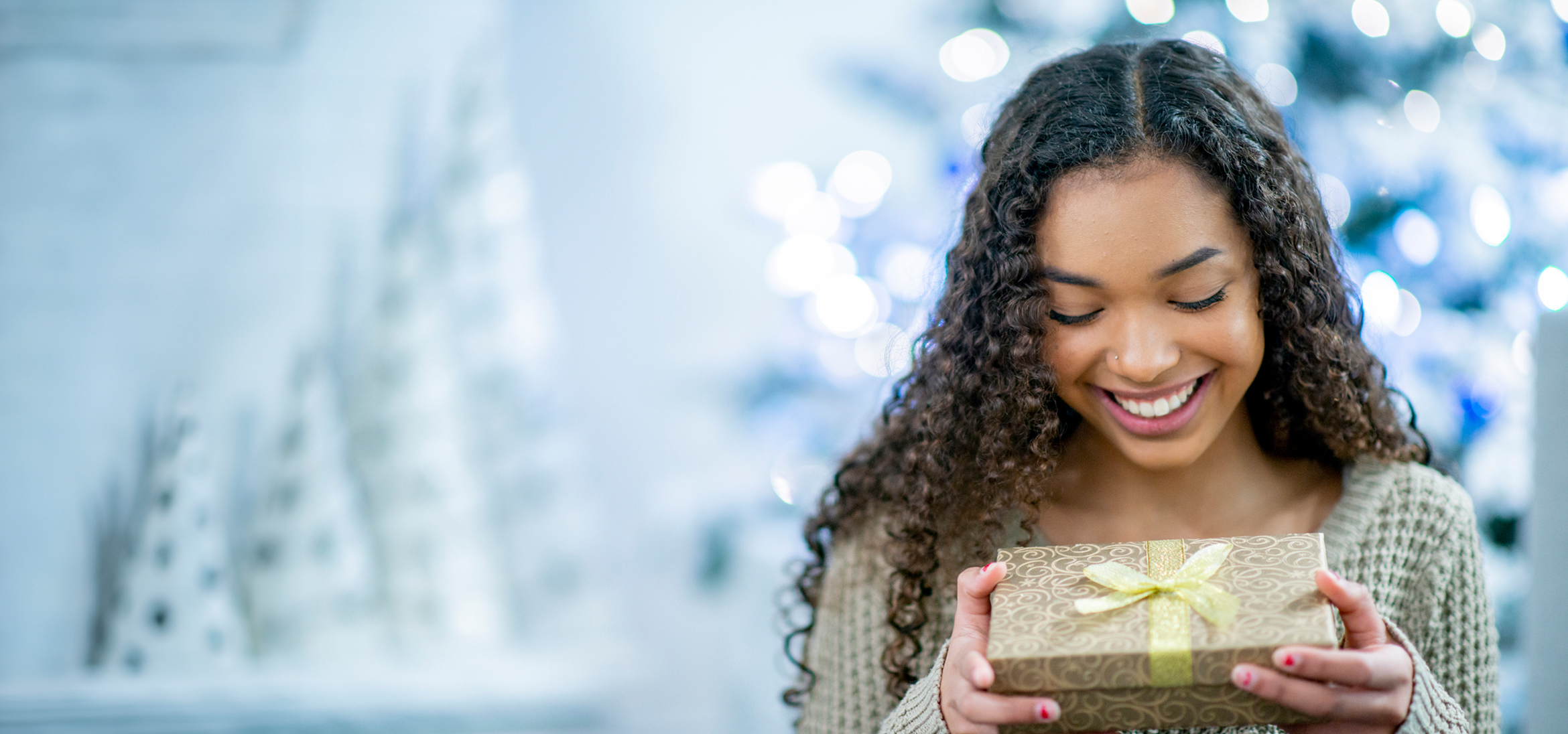 Patelco Student Checking member opening a present for the holidays