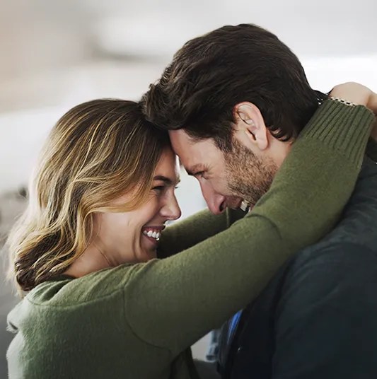 Couple holding each other close and smiling